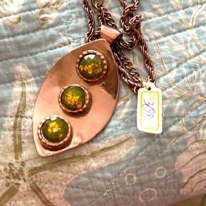 Coppery looking pendant with THREE green and gold leaf faceted raised cabochons